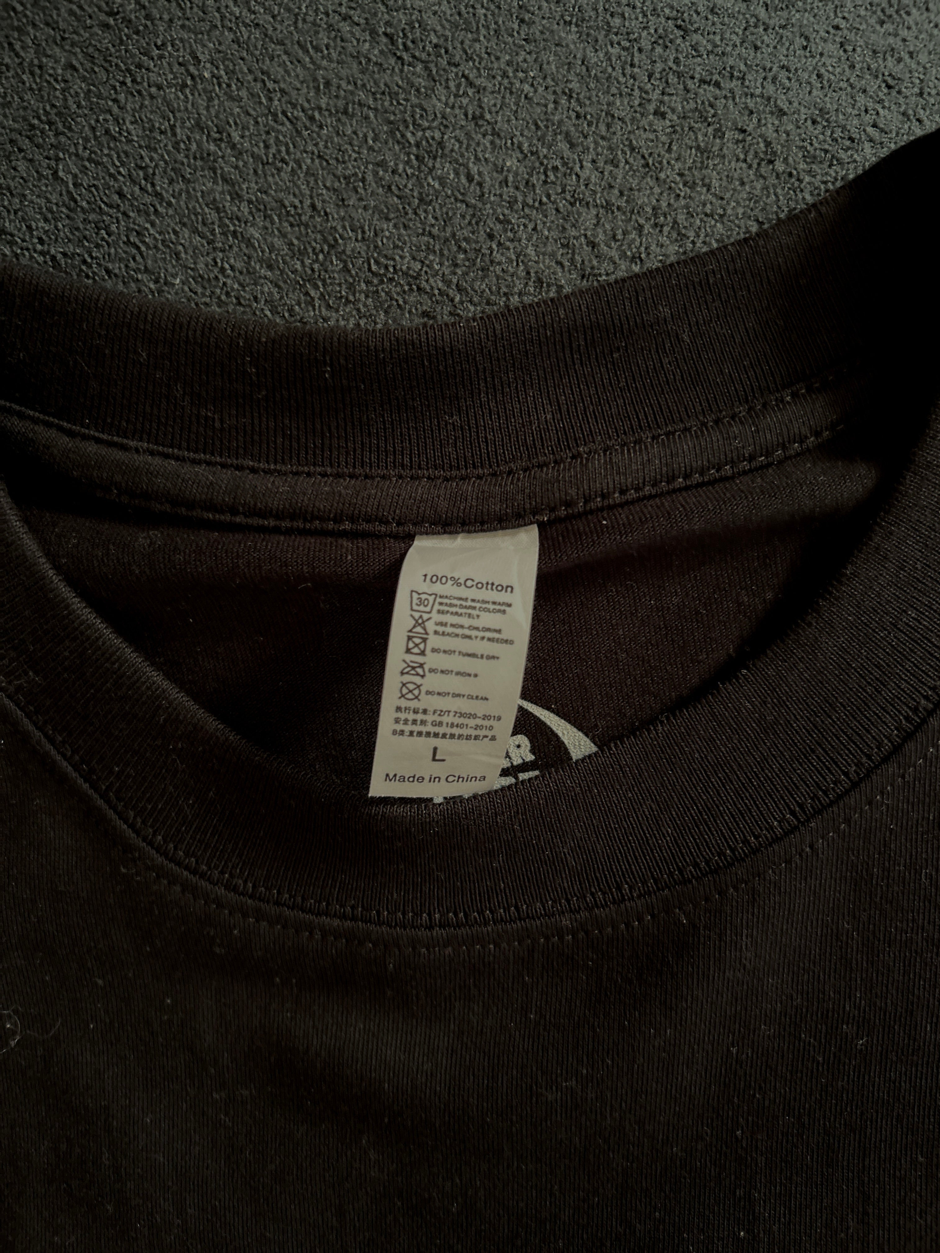 Close-up of a black hoodie with a tag on a gray surface